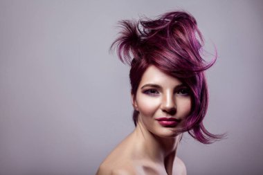 mutlu güzel moda model kadın kısa mor renkli saç modeli ve mutluluk ile kameraya bakarak ve gri arka plan üzerinde gülümseyen makyaj ile portresi.