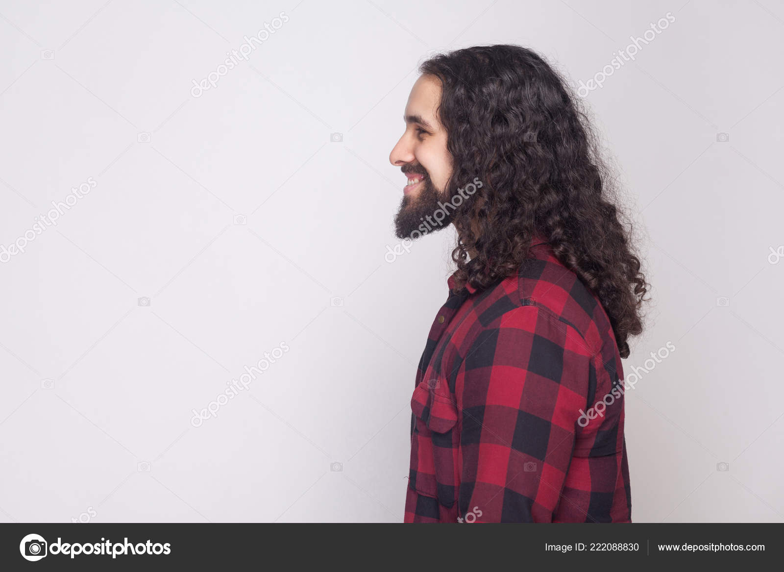 Um homem sério e bonito com cabelo encaracolado e camisa xadrez