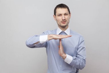 Gri arka plan üzerinde zaman aşımı hareketi ile işadamı yalvaran 