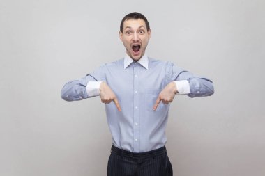 Boşaltmak işaret ve kameraya hayran suratla gri arka plan üzerinde seyir sürpriz işadamı portresi