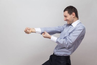 yan görünümü gri arka plan üzerine çekerek jest yapmaya çalışan çalışkan işadamı portresi 