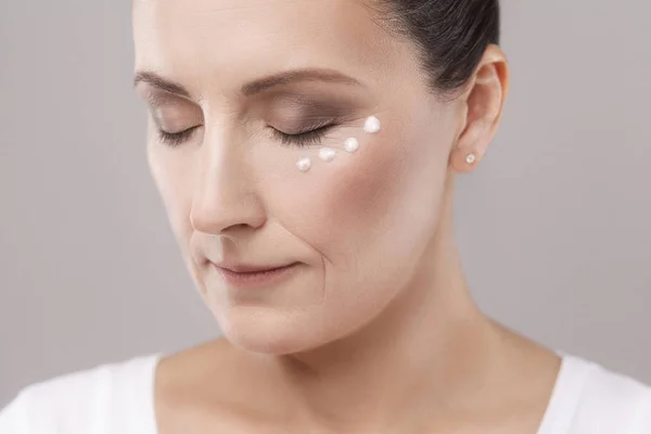 Mujer Mediana Edad Aplicando Crema Sobre Piel Cerca Los Ojos — Foto de Stock