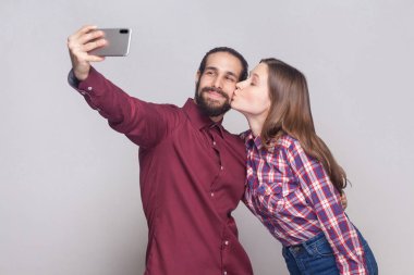 Ayakta ve selfie gri arka plan üzerinde yapıyor aşk memnun kaç mutlu portresi.