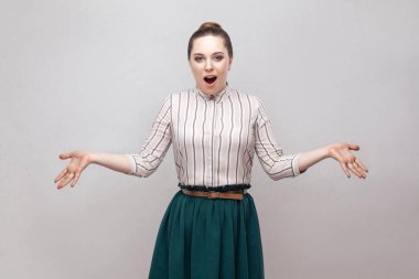 Şok kadında kaldırdı kollarını açarak ayakta ve açık ağzı ile kameraya bakarak toplanan yasağı saç modeli ile gömlek ve yeşil etek çizgili 