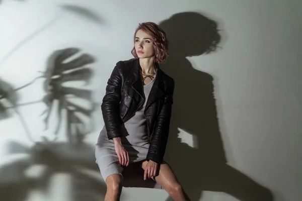 Frau Grauem Kleid Und Schwarzer Lederjacke Posiert Auf Grauem Hintergrund — Stockfoto