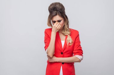 Saç ve makyaj gözleri dokunmaktan ve ağlayan kırmızı süslü blazer ile mutsuz mutsuz güzel iş kadını portresi 