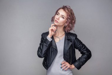 Güzel düşünce portre kısa pembe saç ve makyaj çenesinin dokunmaktan ve seyir siyah deri ceketli olan kadın 