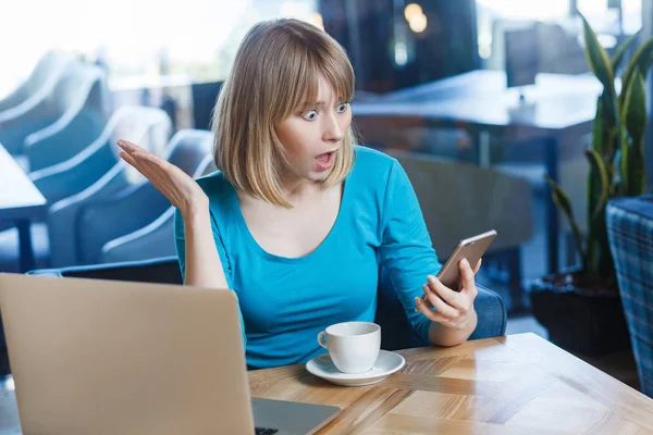 Young Shocked Blonde Woman Blue Blouse Sitting Cafe Holding Smartphone — Stock Photo, Image