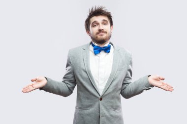 sıradan gri renk takımlı ve mavi ile boşanmış silah duran ve kameraya ışık gri arka plan üzerinde seyir papyon yakışıklı sakallı adam karıştı.