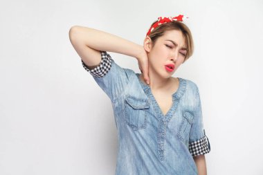 üzgün genç kadın rahat mavi kot gömlek Kapalı gözlerle ayakta ve ağrılı boyun beyaz arka plan üzerinde izole tutan makyaj ve kırmızı kafa bandı ile.