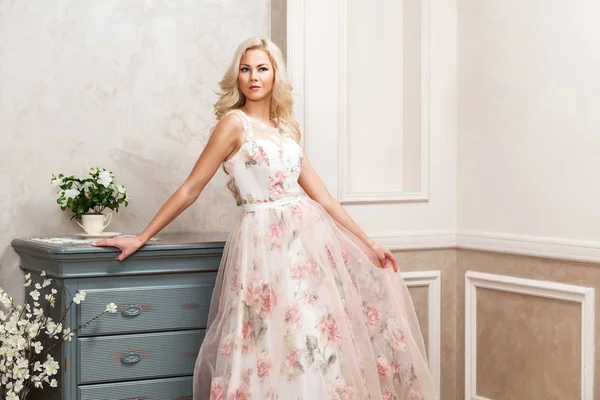 Piękna Blondynka Pastelowych Sukienka Kwiatowy Opierając Się Komodzie Domu — Zdjęcie stockowe