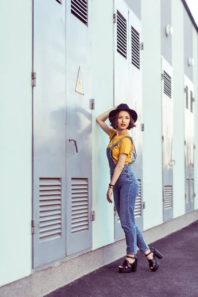 Young Woman Blue Denim Overalls Yellow Shirt Black Hat Sensual — Stock Photo, Image