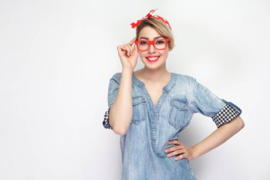 Makyaj ve kırmızı kafa bandı ile rahat mavi denim gömlek güzel genç kadın portre beyaz arka planda izole todülü gülümseme ile kamera bakıyor