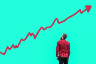 Back view of bearded handsome businessman in red shirt standing and looking at painted growing graph chart on blue background clipart