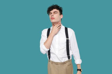 klasik rahat beyaz gömlek yakışıklı hipster genç işadamı ve askıda ağrılı boyun tutan ve mavi arka plan üzerinde poz verirken kötü duygu.