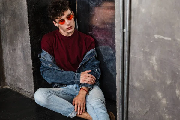 Stilvoller Mann Mit Heller Sonnenbrille Und Jeans Lässig Sitzend Während — Stockfoto