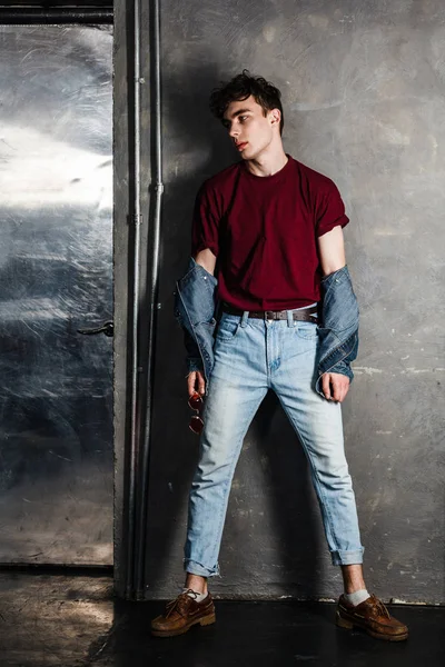 Homem Elegante Estilo Casual Jeans Enquanto Inclina Parede Concreto Olhando — Fotografia de Stock