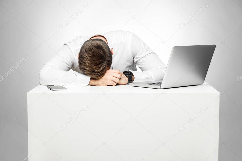 sleepy tired freelancer in white shirt snoozing at work place near laptop