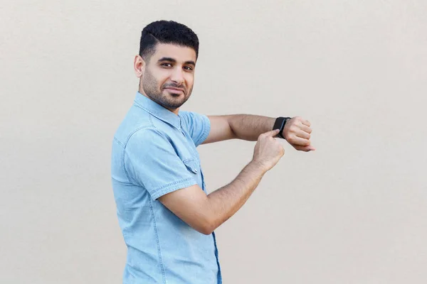 Nöjd Snygg Ung Skäggiga Man Blå Skjorta Pekar Smart Watch — Stockfoto
