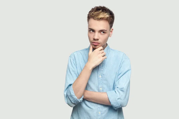 Omtänksamt Stilig Ung Man Ljusblå Skjorta Håller Hakan Och Tittar — Stockfoto