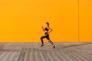 Siyah sporwea giyen genç çekici sportif kadın Yan görünümü