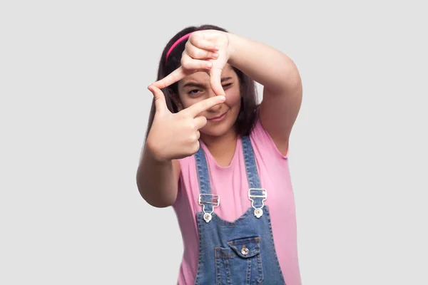 Attentive Brunette Young Girl Pink Shirt Blue Denim Overalls Standing — Stock Photo, Image