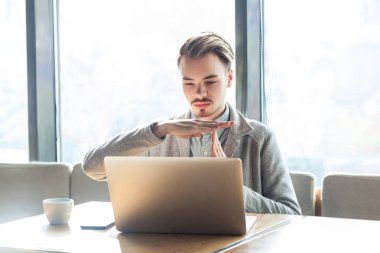 uyarı yakışıklı sakallı genç freelancer gri blazer kafede oturan ve duraklatma jesti gösterirken dizüstü bilgisayarda görüntülü arama yapma 