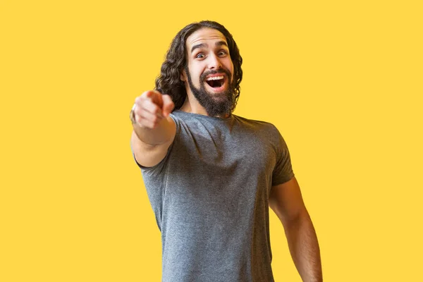 Surprised Bearded Young Man Long Curly Hair Grey Shirt Pointing — Stock Photo, Image