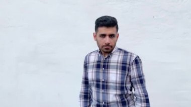 mavi damalı gömlek boks yumrukları ile ayakta ve beyaz duvar arka plan üzerinde delme hazır kızgın ciddi yakışıklı sakallı adam 