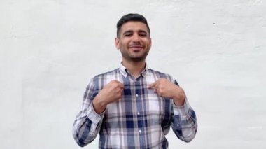 mavi damalı gömlek mutlu yakışıklı sakallı adam kendini işaret ve beyaz duvar arka plan üzerinde kamera bakarken gülümseyerek