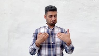 beyaz duvar arka plan üzerinde kibirli kendinden emin yüz ile bakarken mavi damalı gömlek gösteren ve kendini gösteren gururlu yakışıklı sakallı adam