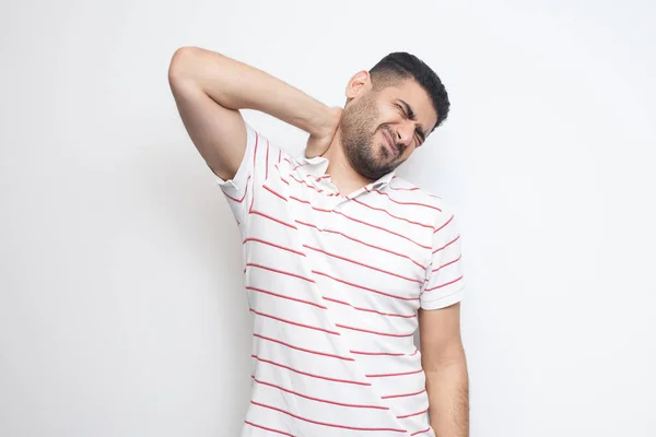 Guapo Barbudo Joven Camiseta Rayas Pie Sosteniendo Doloroso Cuello Aislado —  Fotos de Stock