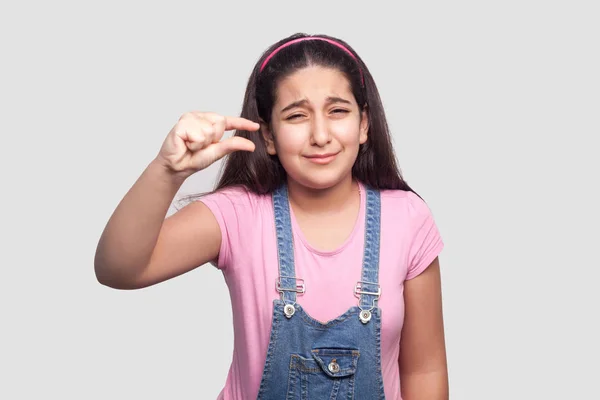 Preocupación Chica Joven Morena Camiseta Rosa Mono Azul Mostrando Pequeño — Foto de Stock