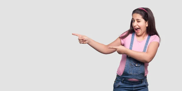 Funny Beautiful Brunette Girl Pink Shirt Blue Overalls Pointing Aside — Stock Photo, Image