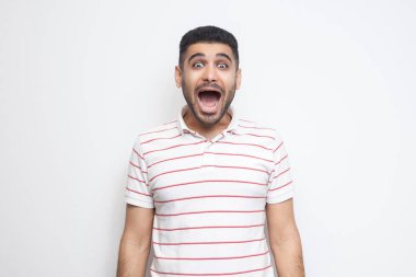 açık ağız ile çizgili t-shirt ayakta yakışıklı sakallı genç adam sürpriz ve beyaz arka planda izole hayran yüzü ile kamera bakıyor.