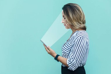 Sarışın kadın ayakta duruyor ve yüzünü tarıyor. Yüz tanıma sistemi akıllı telefonda, mobil biyometrik tanımlama ve yüz tanıma konsepti 