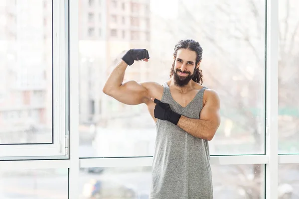 Spokojenost Mladého Dospělého Svalstva Kudrnatými Dlouhými Vlasy Ukazujícími Prstem Biceps — Stock fotografie