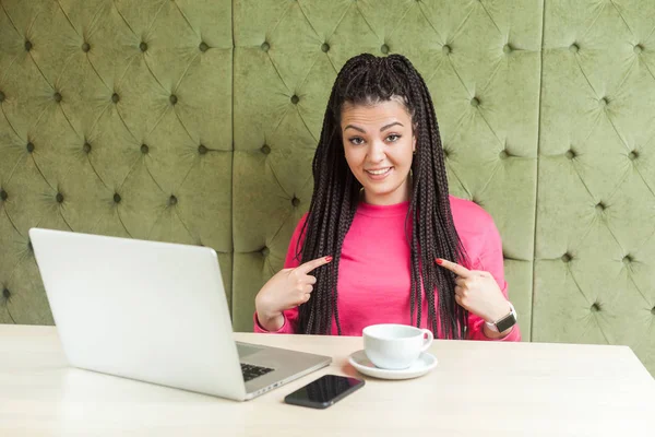 Siyah Rastalı Pembe Bluzlu Genç Bir Kadın Gülümseyerek Parmaklarını Göstererek — Stok fotoğraf