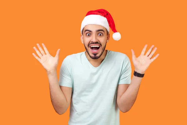 Verbaasd Gelukkig Bebaarde Jongeman Kerstman Hoed Casual Wit Shirt Staan — Stockfoto