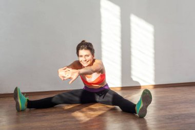 Acemi esneme, ısınma hareketleri. Bun saç stili olan pozitif kadın. 