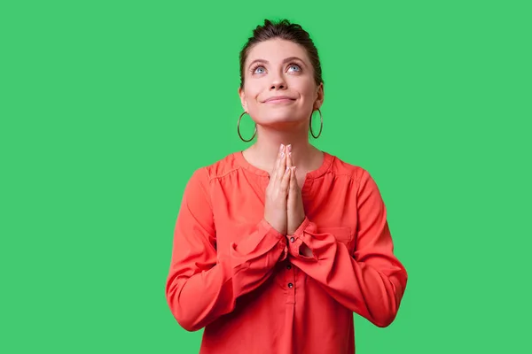 身穿红衫 头戴发髻 头戴大耳环的年轻女子 双手举着绿色背景的祈祷者 — 图库照片