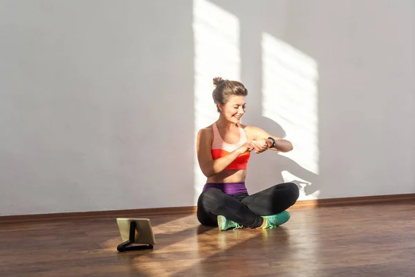 Satisfeito mulher desportiva com penteado de pão e em sportswea apertado — Fotografia de Stock