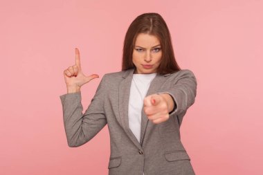 - Kovuldun! İş elbisesi giymiş hoşnutsuz genç bir kadının resmi kamerayı gösteriyor ve L 'yi parmaklarıyla işaret ettiriyor, ezik jestleri yapıyor, başarısızlıkla suçluyor. Stüdyo çekimi, pembe arkaplan