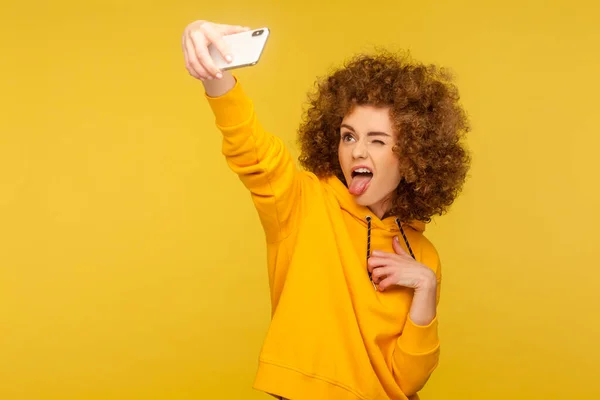 Portret Beztroskiej Dziewczyny Kręconymi Włosami Miejskiej Bluzie Kapturem Robiącej Selfie — Zdjęcie stockowe
