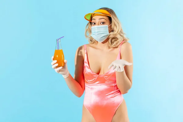 Don\'t know how drink safe! Uncertain woman in swimsuit, hygienic mask and gloves, having troubles with beverage, feeling helpless confused, doubting and afraid to get infected coronavirus. isolated