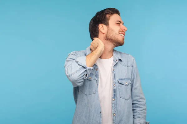 Retrato Homem Jovem Exausto Camisa Jeans Tocando Pescoço Sorrindo Dor — Fotografia de Stock