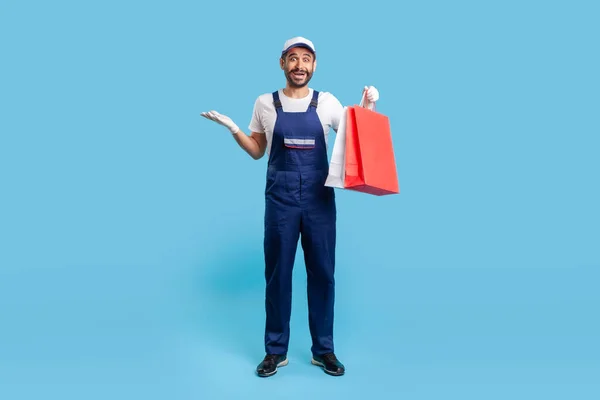 Full Length Portrait Surprised Courier Uniform Holding Shopping Bags Looking — Zdjęcie stockowe