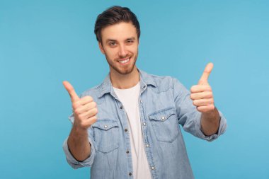 Well done, excellent job! Portrait of smiling satisfied man in worker denim shirt standing with thumbs up, like gesture, demonstrating approval and agree with suggestion. indoor studio shot isolated clipart