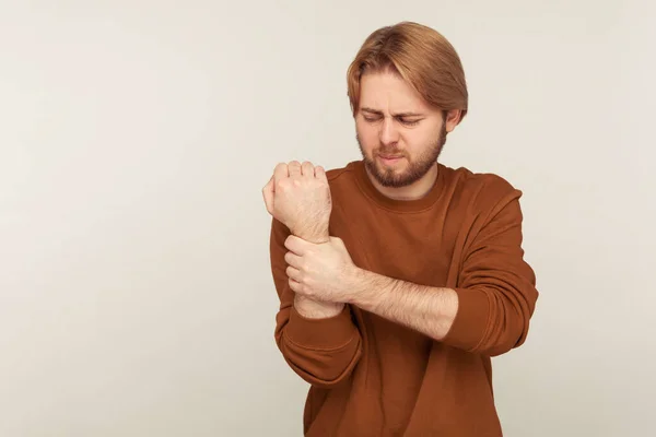 Sprain Wrist Portrait Bearded Man Sweatshirt Massaging Sore Arm Feeling — Stock fotografie