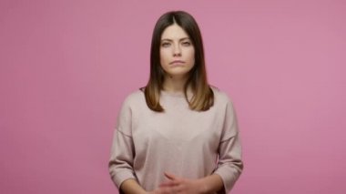 Hey sen, dikkatli ol! Esmer, genç bir kadın. Parmakla uyarıp, tehlike uyarısı yaparak azarlıyor. Onaylamadığını gösteriyor. Stüdyo çekimi pembe arkaplanda izole edildi